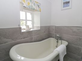 A bathroom with a bathtub and a window at Dewi Villa in Aberarth, Ceredigion