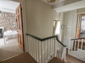 A hallway with a staircase and doors to rooms at Dewi Villa Aberarth, Ceredigion