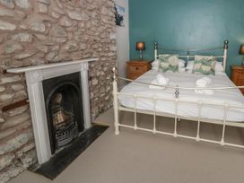 A bedroom with a bed and fireplace at Dewi Villa Aberarth, Ceredigion