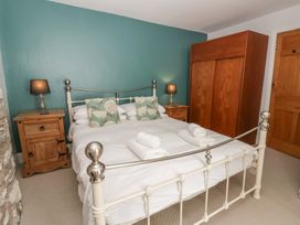 A bedroom with a bed and wooden furniture at Dewi Villa in Aberarth, Ceredigion