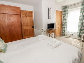A bedroom with a bed and wardrobe at Dewi Villa Aberarth, Ceredigion