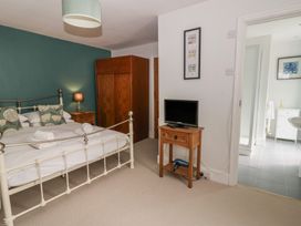 A bedroom with a bed, wardrobe, and television at Dewi Villa, Aberarth, Ceredigion