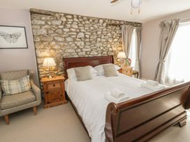 A bedroom with a bed and stone wall at Dewi Villa in Aberarth, Ceredigion