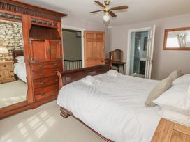 A bedroom with a bed and wardrobe at Dewi Villa, Aberarth, Ceredigion