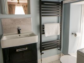 A bathroom with sink, towel rail, and toilet at Dewi Villa, Aberarth, Ceredigion
