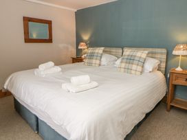 A bedroom with a double bed and lamp at Dewi Villa Aberarth, Ceredigion