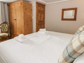 A bedroom with a bed and wardrobe at Dewi Villa Aberarth, Ceredigion