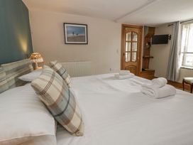 A bedroom with a bed and framed picture at Dewi Villa in Aberarth, Ceredigion