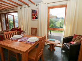 A dining room with a table set for dinner at Dan Castell Cottage in Llandeilo, Carmarthenshire