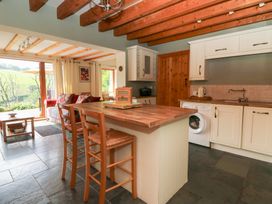 A kitchen with a kitchen island and washing machine at Dan Castell Cottage in Llandeilo, Carmarthenshire