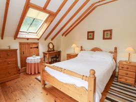 A bedroom with a bed and furniture at Dan Castell Cottage in Llandeilo, Carmarthenshire