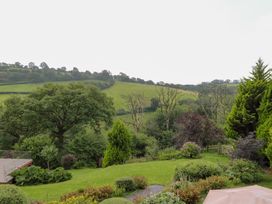 A garden with trees and a view of hills at Dan Castell Cottage in Llandeilo, Carmarthenshire
