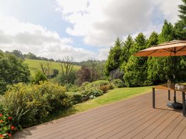 An outdoor area with a table and umbrella at Dan Castell Cottage in Llandeilo, Carmarthenshire