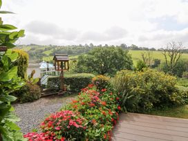 A garden with a flower bed and bird feeder at Dan Castell Cottage in Llandeilo, Carmarthenshire