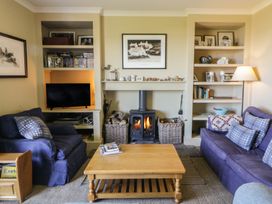A living room with a sofa, coffee table, and fireplace at Dolwylan, Newport, Pembrokeshire