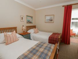 A bedroom with two single beds and a nightstand at Dolwylan in Newport, Pembrokeshire