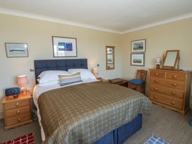 A bedroom with a bed and wooden furniture at Dolwylan in Newport, Pembrokeshire