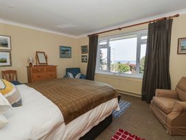 A bedroom with a bed and large window at Dolwylan in Newport, Pembrokeshire
