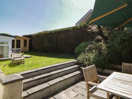 A garden with wooden chairs, table, and steps at Dolwylan in Newport, Pembrokeshire