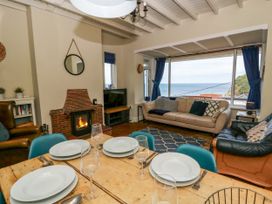 A living room with a sofa and fireplace at Delyn Aur in Tresaith, Ceredigion