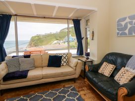 A living room with sofas and a view of the coast at Delyn Aur Tresaith, Ceredigion