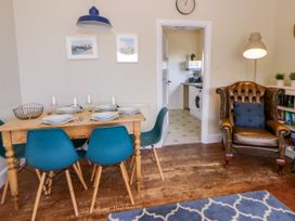 A dining room with a wooden table and chairs at Delyn Aur, Tresaith, Ceredigion