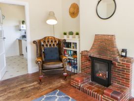 A living room with an armchair and fireplace at Delyn Aur in Tresaith, Ceredigion