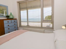 A bedroom with a window and dresser at Delyn Aur Tresaith, Ceredigion