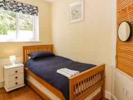 A bedroom with a single bed and bedside table at Delyn Aur Tresaith, Ceredigion