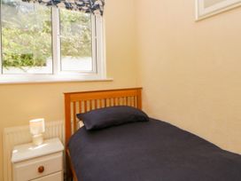 A bedroom with a single bed and a window at Delyn Aur Tresaith, Ceredigion