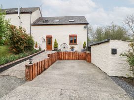 A driveway and entrance area with a white building and wooden door at Mill Barn Denant in Haverfordwest Pembrokeshire