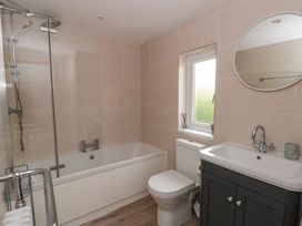 A bathroom with a shower, bath, toilet, and sink at Little Barn Cottage, Dinas Cross, Pembrokeshire