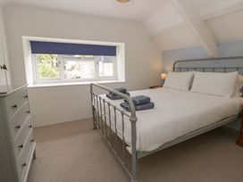 A bedroom with a bed and dresser at Little Barn Cottage in Dinas Cross, Pembrokeshire