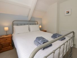 A bedroom with a bed and bedside tables at Little Barn Cottage, Dinas Cross, Pembrokeshire