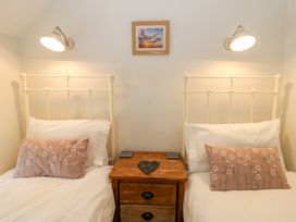 Two beds with pillows and a nightstand at Little Barn Cottage Dinas Cross, Pembrokeshire