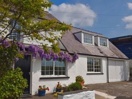A house with purple flowers and windows at Beach Retreat in Aberporth