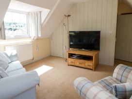 A living room with a television on a stand at Beach Retreat in Aberporth