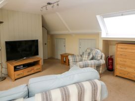 A living room with a television and armchair at Beach Retreat in Aberporth