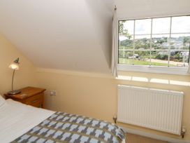 A bedroom with a bed and lamp at Beach Retreat in Aberporth