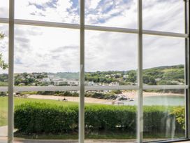 A view of a beach and houses through a window at Beach Retreat in Aberporth