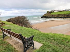 A beach view with a bench and grass at Beach Retreat in Aberporth