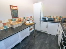 A kitchen with countertops appliances and a tiled backsplash at Newton West Farm in Newton near Newgale