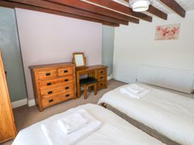 A bedroom with two single beds white bedding and towels wooden dresser and vanity with stool Newton West Farm Newton near Newgale