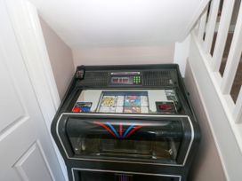 A vintage jukebox placed in a small corner under a staircase