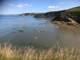 A beach with people and boats at Beach Cottage in Little Haven, Pembrokeshire