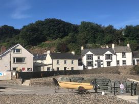 A coastal view with houses and a boat at Beach Cottage in Little Haven, Pembrokeshire