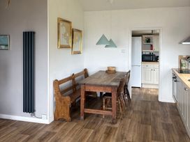 A kitchen with a dining area featuring a table and chairs at Beach Cove Freshwater East Pembrokeshire