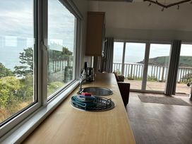 A kitchen with a sink and sea view at Beach Cove Freshwater East Pembrokeshire