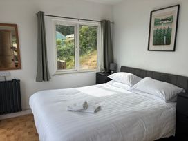 A bedroom with a double bed and window at Beach Cove Freshwater East, Pembrokeshire
