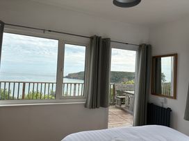 A bedroom with a sea view window at Beach Cove Freshwater East, Pembrokeshire